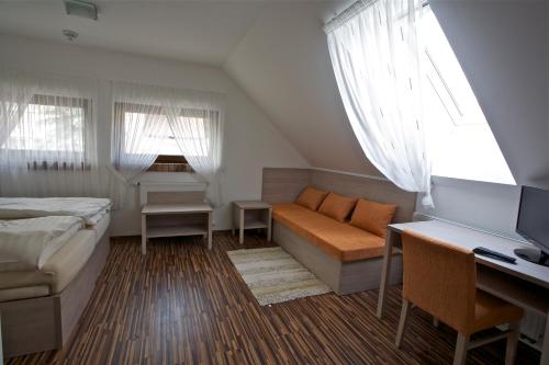 ein Schlafzimmer mit einem Bett, einem Sofa und einem Schreibtisch in der Unterkunft Pútnický mlyn in Marianka