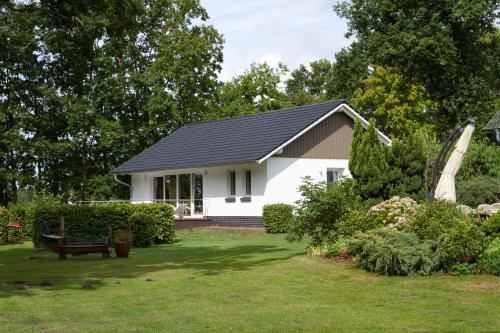 a white house with a black roof in a yard at Hotel-Marks-Garni in Zingst