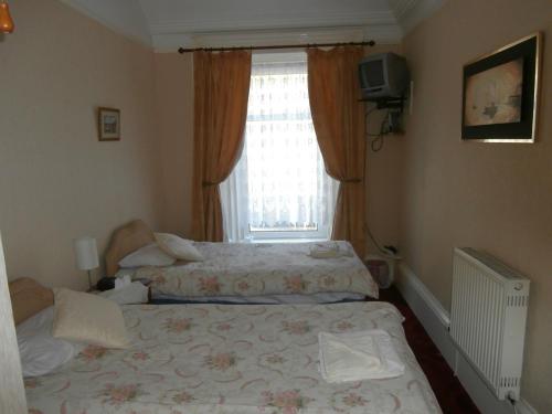 a bedroom with a bed in front of a window at Monorene Guest House in Galashiels