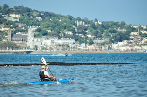 a man is sitting on a kayak in the water at Rosemead Guest House in Paignton