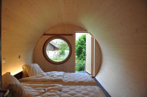 een kamer met een bed en een rond raam bij Rüedi - Fasstastische Ferien in Trasadingen