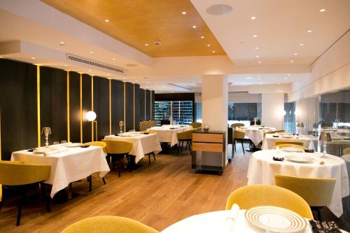 a restaurant with white tables and yellow chairs at Ohla Barcelona in Barcelona