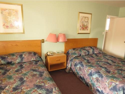 a hotel room with two beds and a table with a phone at Satelite Motel in Sault Ste. Marie