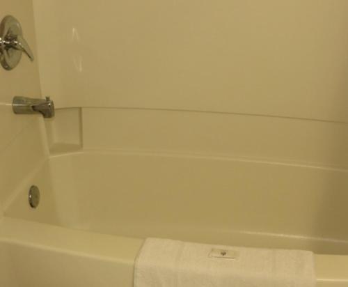a white bath tub in a bathroom with a towel at Satelite Motel in Sault Ste. Marie