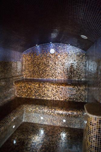 a bathroom with a stone wall with a tub at SPA Amber Palace in Šventoji