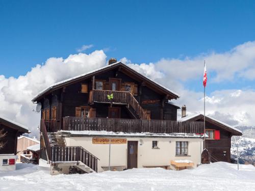 a wooden building with a balcony in the snow at Gruppenhaus im Walliser Alpstyle in Rosswald