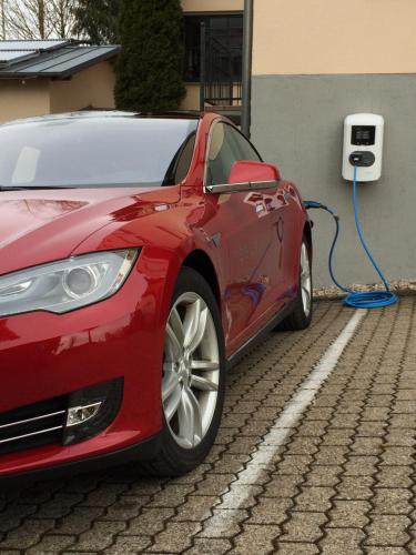 a red car is plugged into a electric car charger at Landhotel Villa Moritz garni in Oberahr