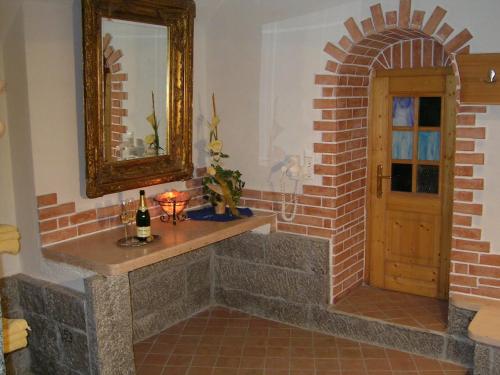 a bathroom with a mirror and a brick wall at Ferienhof Kampfl in Fügen