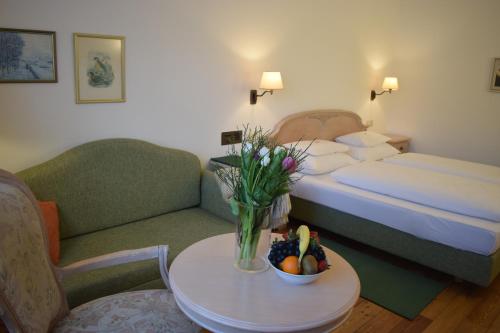 a hotel room with a bed and a table with a bowl of fruit at Hotel Landhaus Fuhrgassl-Huber in Vienna