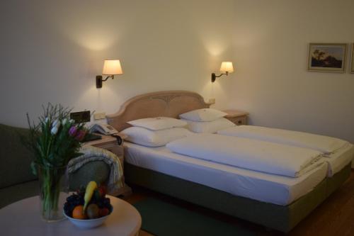a hotel room with two beds and a table with flowers at Hotel Landhaus Fuhrgassl-Huber in Vienna