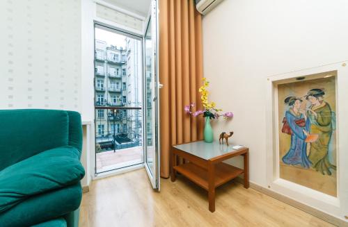 a living room with a green couch and a table at Apartments on Independence Square in Kyiv