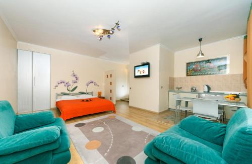 a living room with two blue couches and a kitchen at Apartments on Independence Square in Kyiv