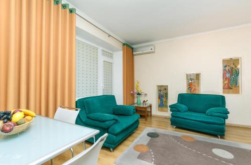 a living room with two green chairs and a table at Apartments on Independence Square in Kyiv