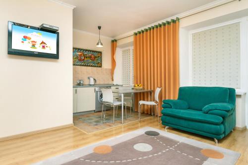 a living room with a green couch and a kitchen at Apartments on Independence Square in Kyiv