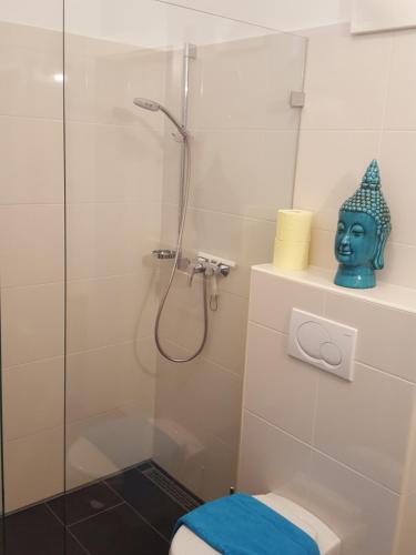 a bathroom with a shower with a mask next to a toilet at Zegg-Lounge in Seeboden