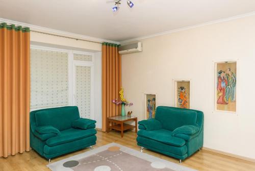 two green chairs sitting in a living room at Apartments on Independence Square in Kyiv