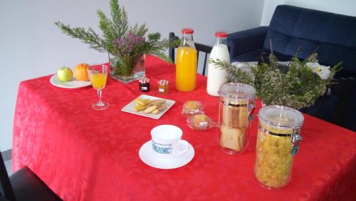 a red table with a red table cloth with food and drinks at Casa do Rio - Penacova in Raiva