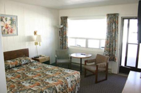 Habitación de hotel con cama, mesa y ventana en Skyline Motel, en Sault Ste. Marie