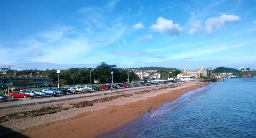 a line of cars parked on a road next to the water at Rosemead Guest House in Paignton