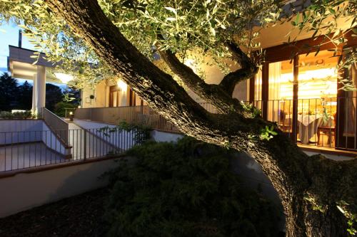 a building with a tree in front of a building at Albergo Ristorante Belvedere in Codroipo