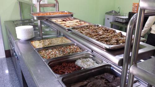 una línea de buffet con muchos tipos diferentes de comida en Residencia Universitaria Cum Laude, en Salamanca