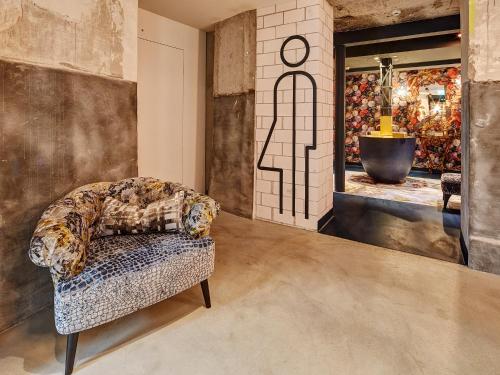 a living room with a chair and a window at Hotel Anker Luzern in Luzern
