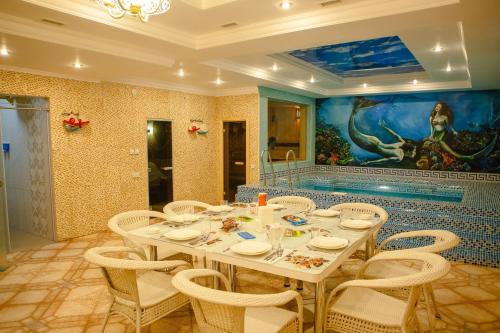 a dining room with a white table and chairs at Luxury House in Shymkent