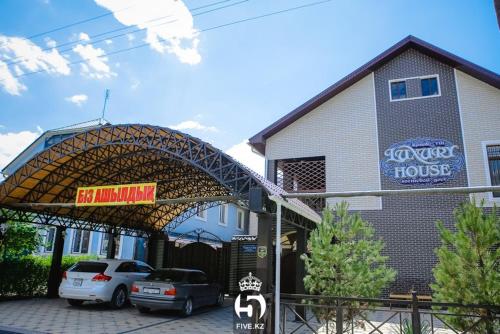 a pizza house with cars parked in front of it at Luxury House in Shymkent
