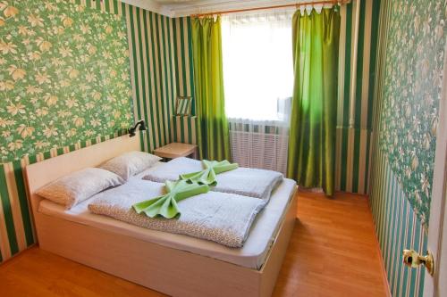 1 dormitorio con 1 cama con cortinas verdes y ventana en Hostel Like, en Riazán
