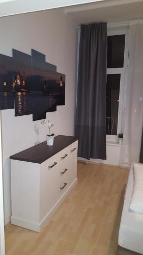 a white dresser in a room with a window at Pension Fischerjung in Rostock