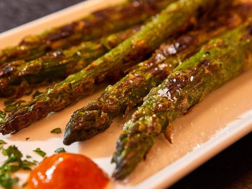 a plate of food with asparagus and a tomato at Hotel Anker Luzern in Luzern