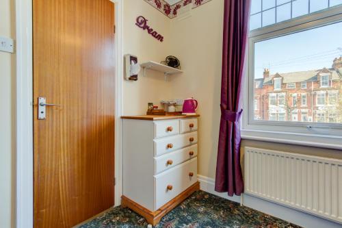 a bedroom with a dresser and a window at Rose-Dene in Scarborough