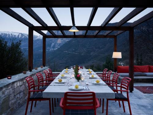 a long table with chairs and plates of food at Aristi Mountain Resort in Aristi