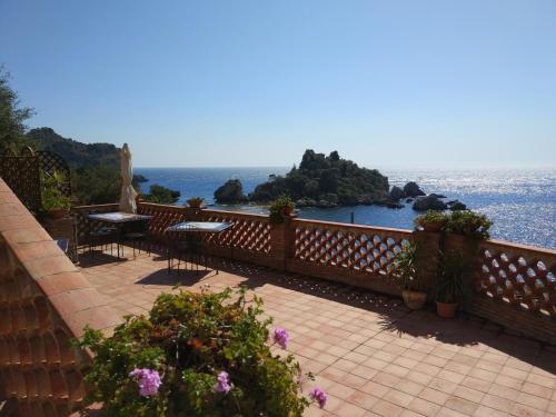 a balcony with tables and a view of the ocean at Isola Bella - Rooms il Pescatore in Taormina