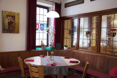 a dining room with a table and chairs and windows at Hotel Gasthof Metzgerei Lamm - Benedikt Rückel in Geiselwind
