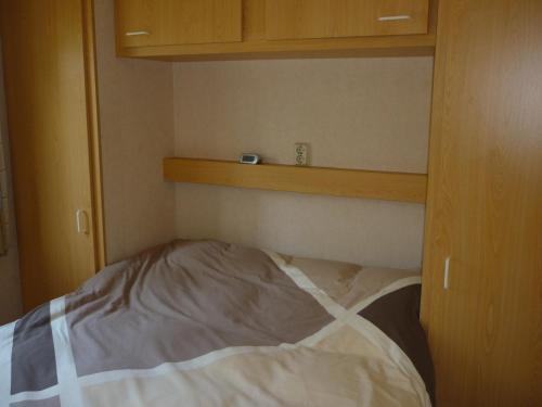 een leeg bed in een kamer met een houten kast bij Chalet Wester Park Lierderholt in Beekbergen