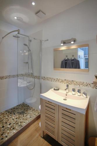 une salle de bain avec un lavabo et une douche dans l'établissement La Maison au-dessus des Voiles, à La Baule