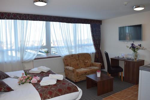 a hotel room with a bed and a chair at Star Anglia Hotel City Center by OYO in Colchester
