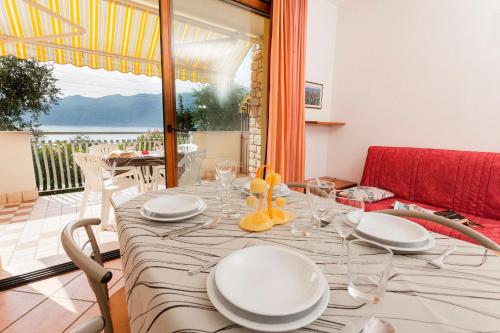 a dining room with a table with plates and glasses at Taki Village in Brenzone sul Garda