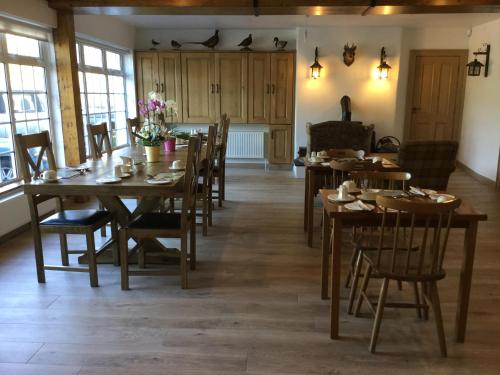 a dining room with wooden tables and chairs at Ryan's River Lodge B&B in Cong