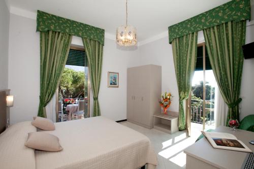 Hotel Giulio Cesare في رابالو: غرفة نوم بسرير ونافذة كبيرة