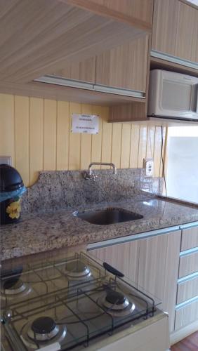 a kitchen with a sink and a counter top at Pousada Campanário in Cambará