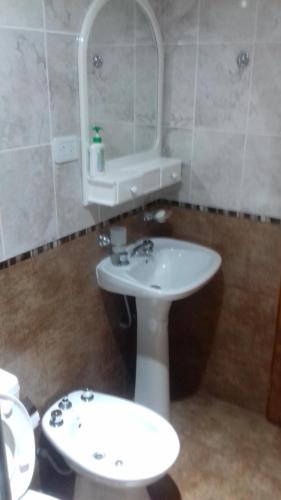 a bathroom with a sink and a mirror and a toilet at Colon M in Colón