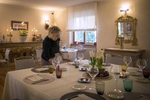 a woman standing in front of a table with wine glasses at Ca' Ada in Faver