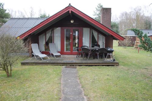 ein Haus mit einer Terrasse mit Stühlen und einem Tisch in der Unterkunft Ferienhaus Gartow in Gartow