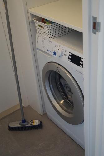 a mop sitting next to a washing machine at An en Bie in Aagtekerke