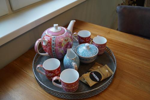 a tray with cups and a tea pot on a table at An en Bie in Aagtekerke