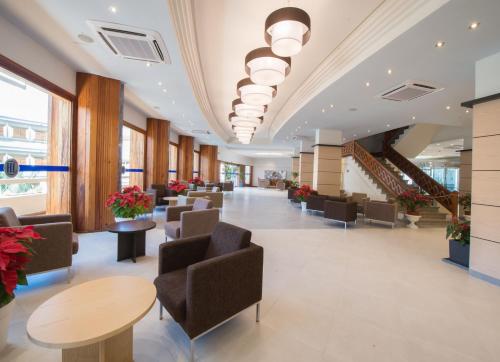 a lobby with chairs and tables and stairs at HL Suitehotel Playa del Inglés - Adults Only in Playa del Ingles