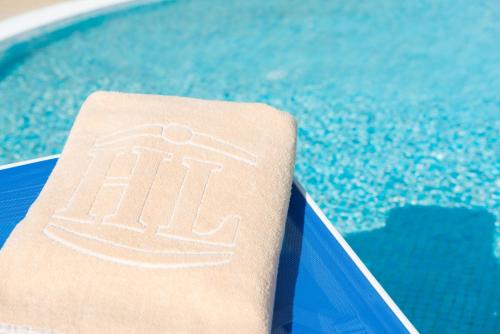 a towel sitting on the edge of a swimming pool at HL Suitehotel Playa del Inglés - Adults Only in Playa del Ingles