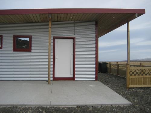 a small building with a white door on it at Ásbrandsstadir Cottages in Vopnafjörður